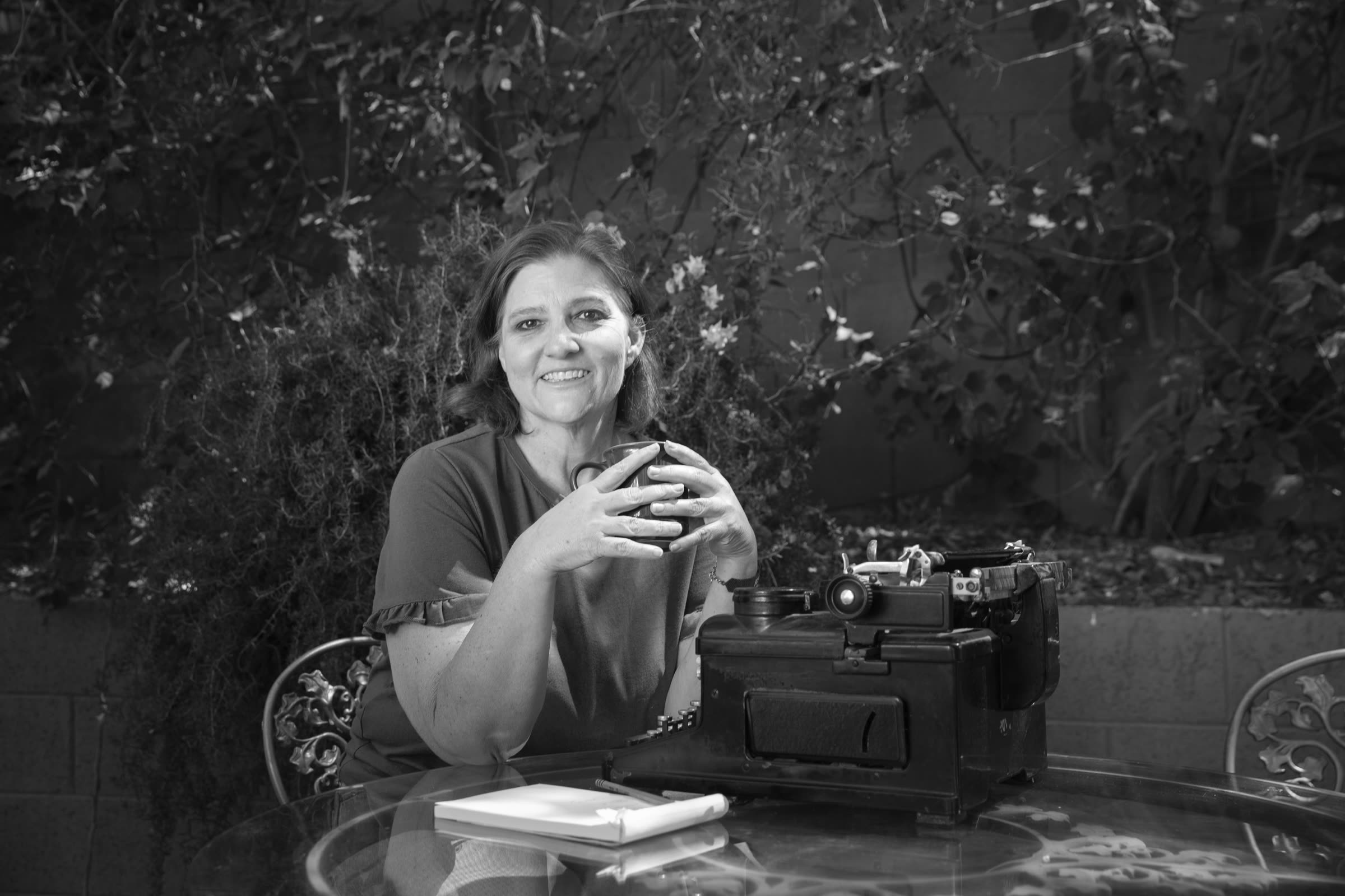 Kelly at a patio table with a vintage typewriter